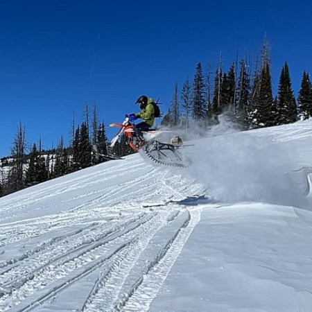 a man riding a snowboard down a snow covered slope