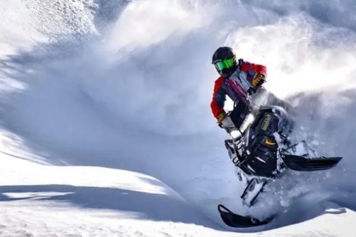 a man riding a snowboard down a snow covered slope