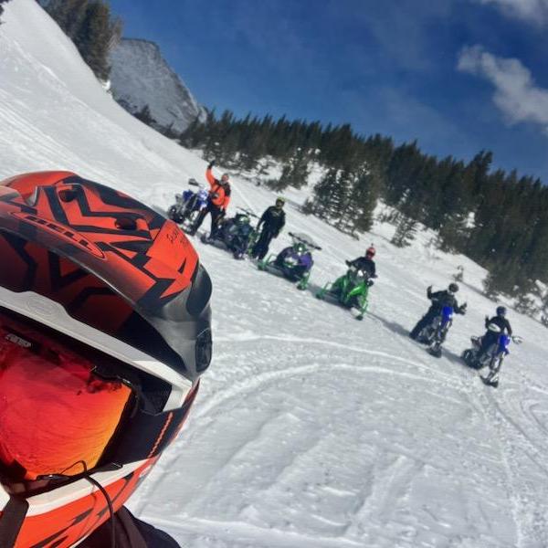 a person riding a snowboard down a snow covered slope