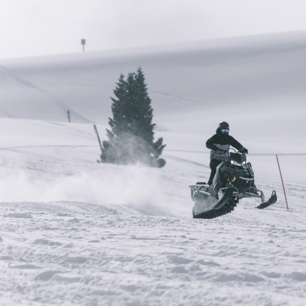 a man riding a snowboard down a snow covered slope