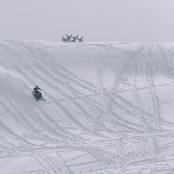 a man riding a snowboard down a snow covered slope