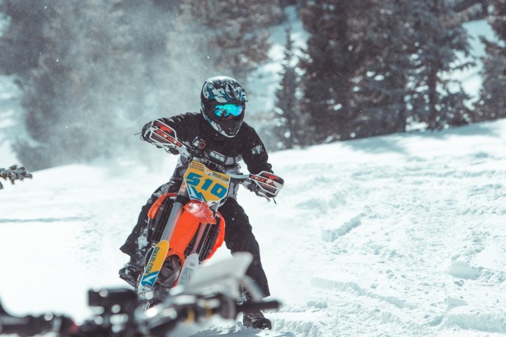 a man riding a snowboard down a snow covered slope