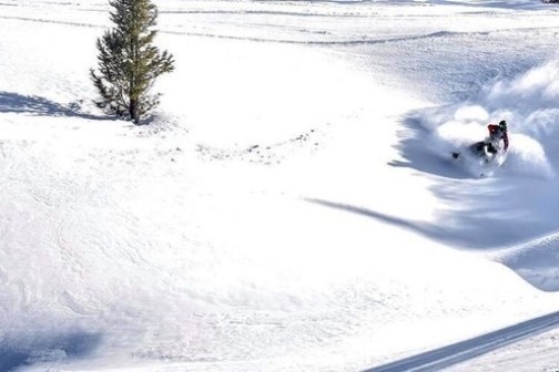 a man riding skis down a snow covered slope